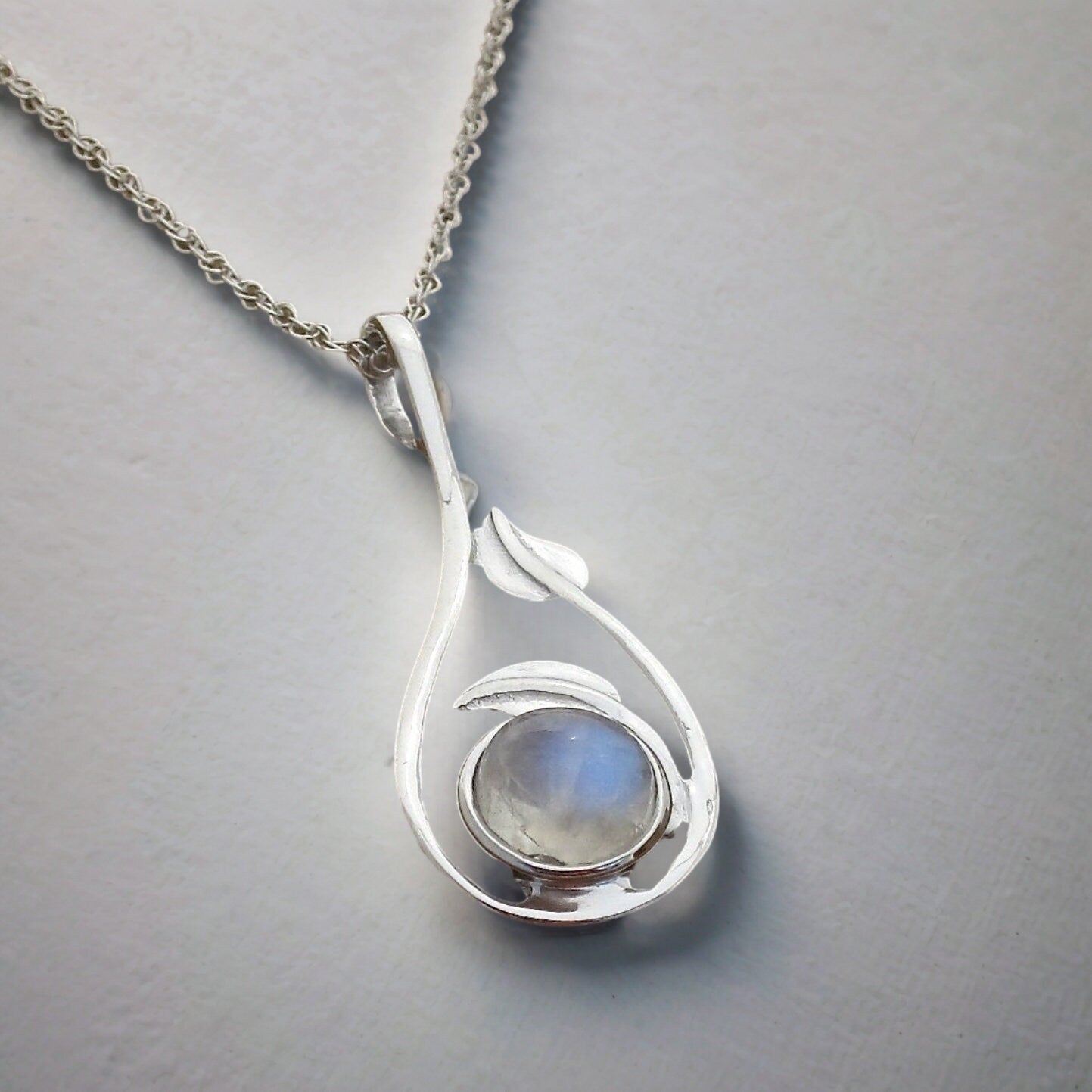 שרשרת כסף עם אבן קשת תלויה ממנה