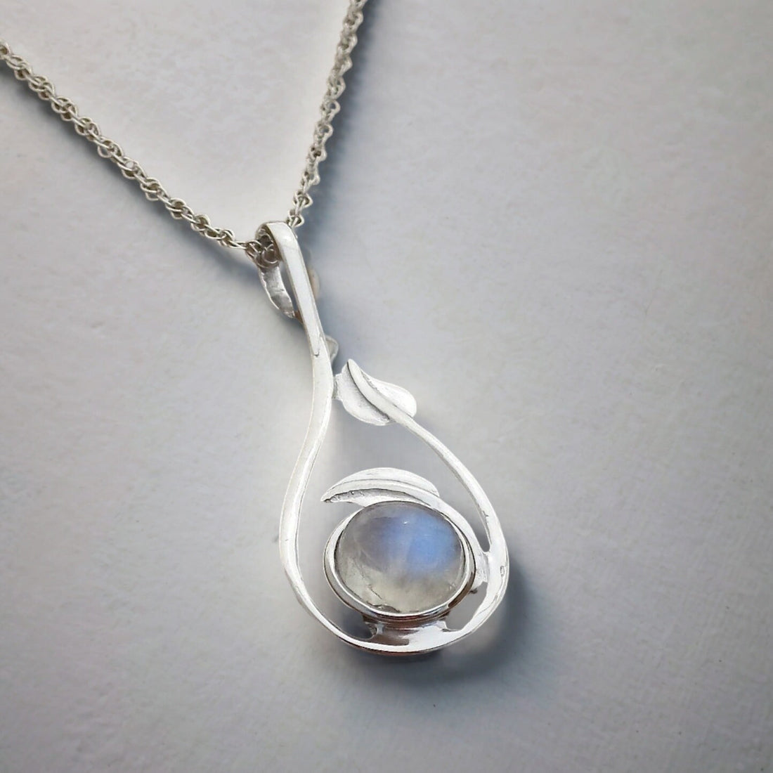 שרשרת כסף עם אבן קשת תלויה ממנה