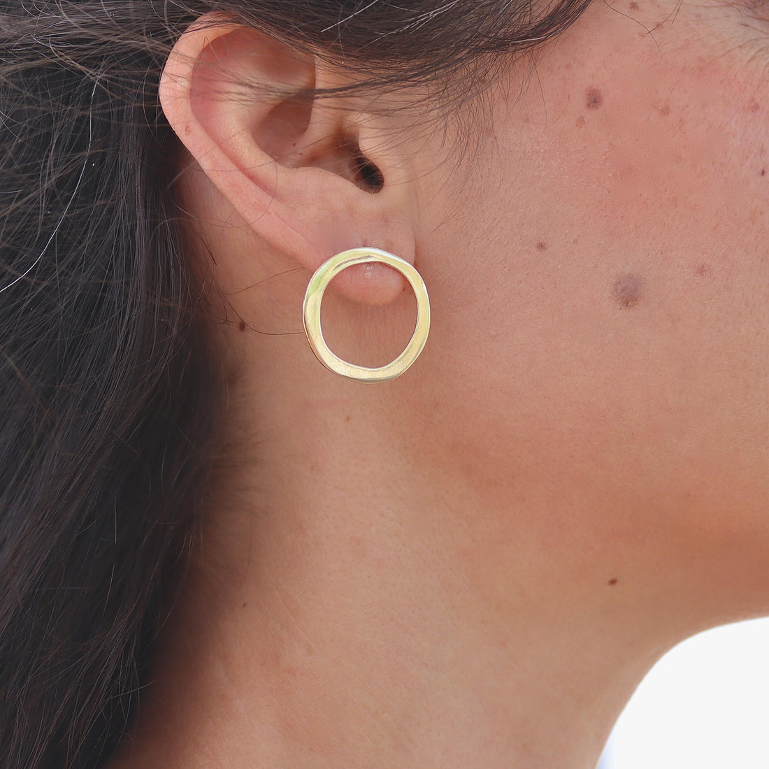 עשוי לכלול: זוג עגילי חישוק זהב. העגילים פשוטים ובעלי צורה עגולה.