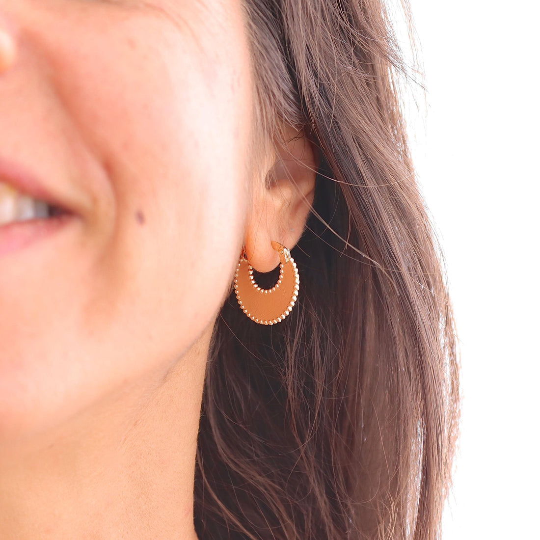 עשוי לכלול: עגילי חישוק זהב עם עיצוב חצי עיגול וקצה חרוזים.