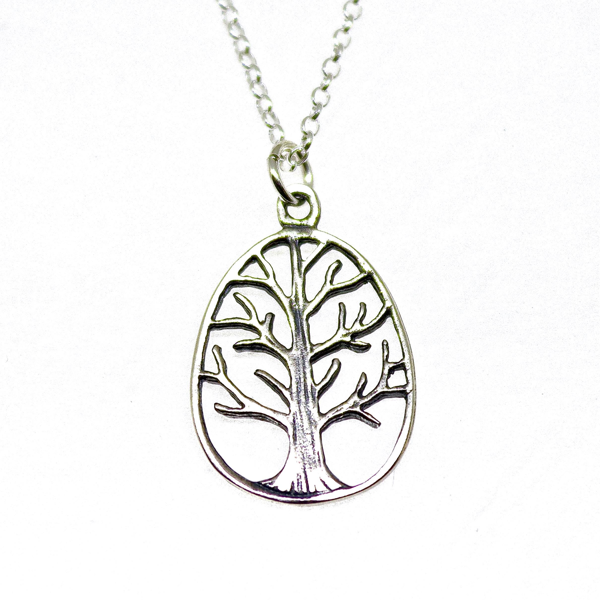 עשוי לכלול: שרשרת עץ החיים מכסף. התליון כולל עיצוב אליפסה בצורת חיתוך של עץ מסוגנן עם ענפים היורדים מגזע עבה. השרשרת היא בסגנון חוליה כסופה עדינה. שרשרת מינימליסטית זו היא מתנה מושלמת לאוהבי טבע ולאלו המעריכים תכשיטים סמליים.
