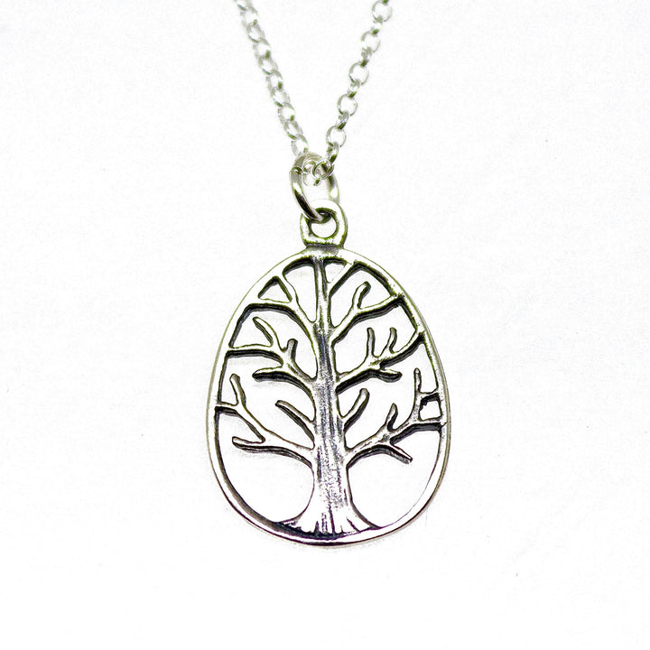 עשוי לכלול: שרשרת עץ החיים מכסף. התליון כולל עיצוב אליפסה בצורת חיתוך של עץ מסוגנן עם ענפים היורדים מגזע עבה. השרשרת היא בסגנון חוליה כסופה עדינה. שרשרת מינימליסטית זו היא מתנה מושלמת לאוהבי טבע ולאלו המעריכים תכשיטים סמליים.