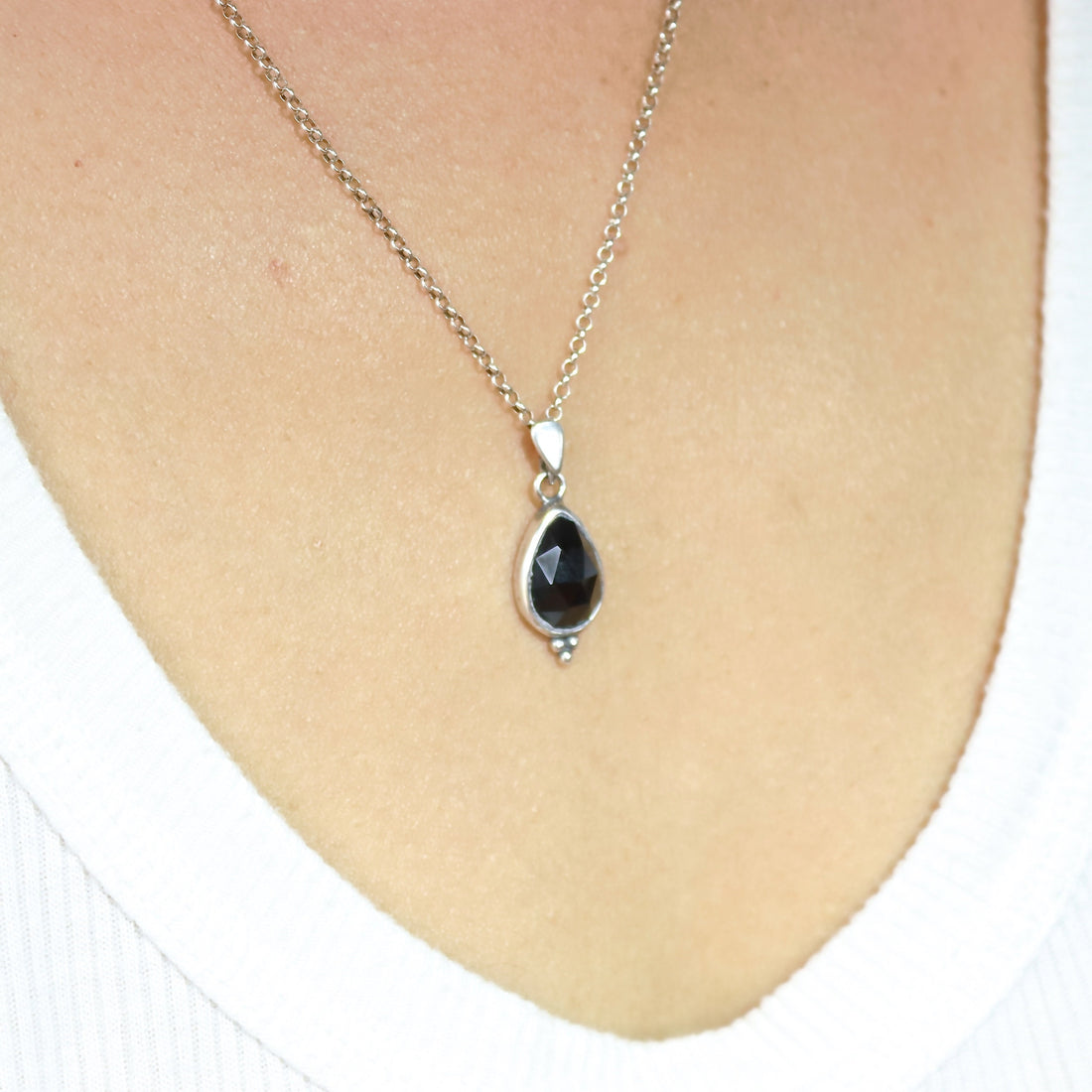עשוי לכלול: שרשרת כסף עם תליון אבן חן שחורה בצורת דמעה