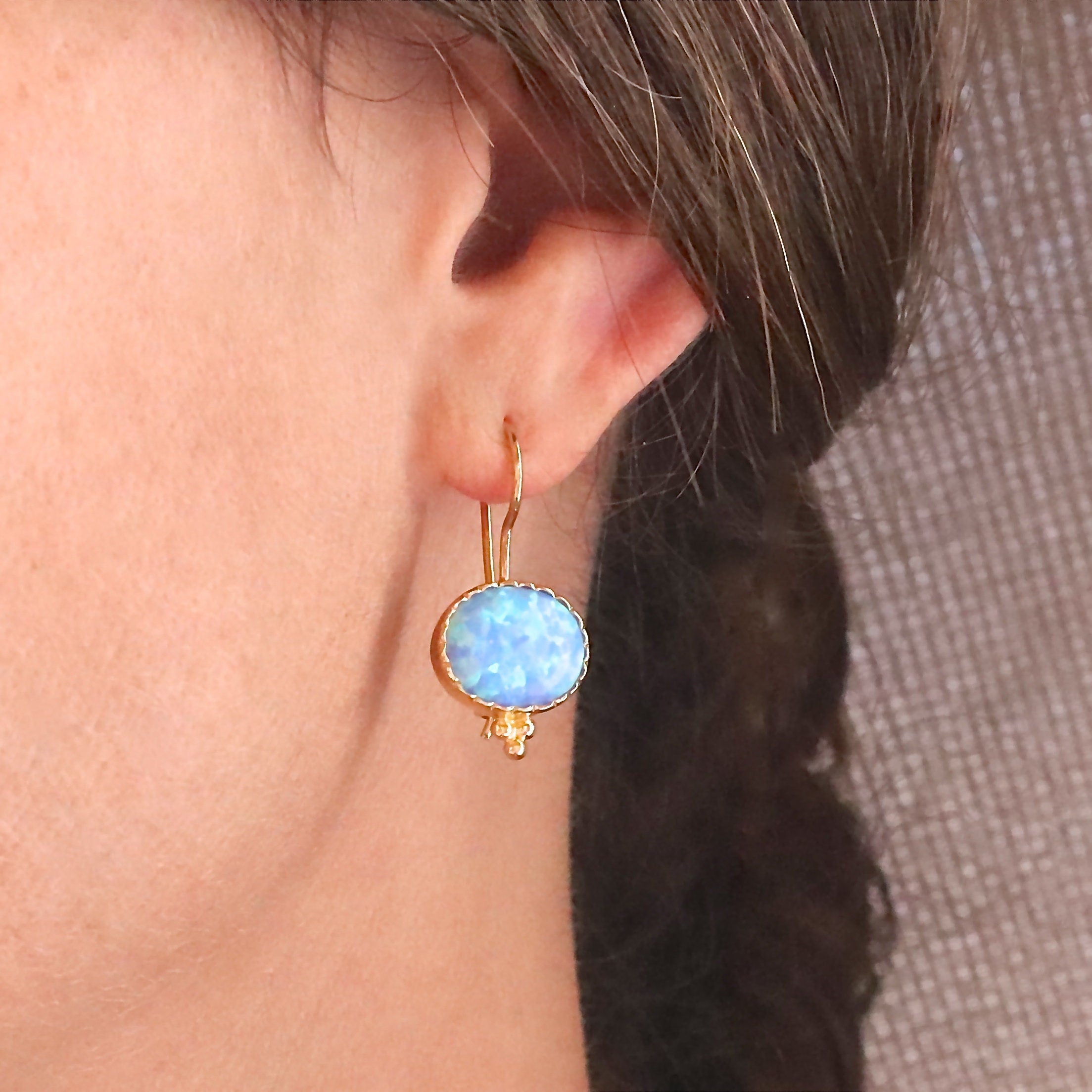 עשוי לכלול: עגילי זהב אובליים עם אבן אופל תכלת