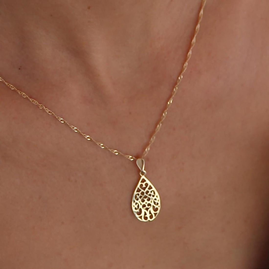 עשוי לכלול: שרשרת זהב עם תליון עדין ומורכב בצורת דמעה. התליון עשוי זהב ובעל עיצוב פיליגרן.